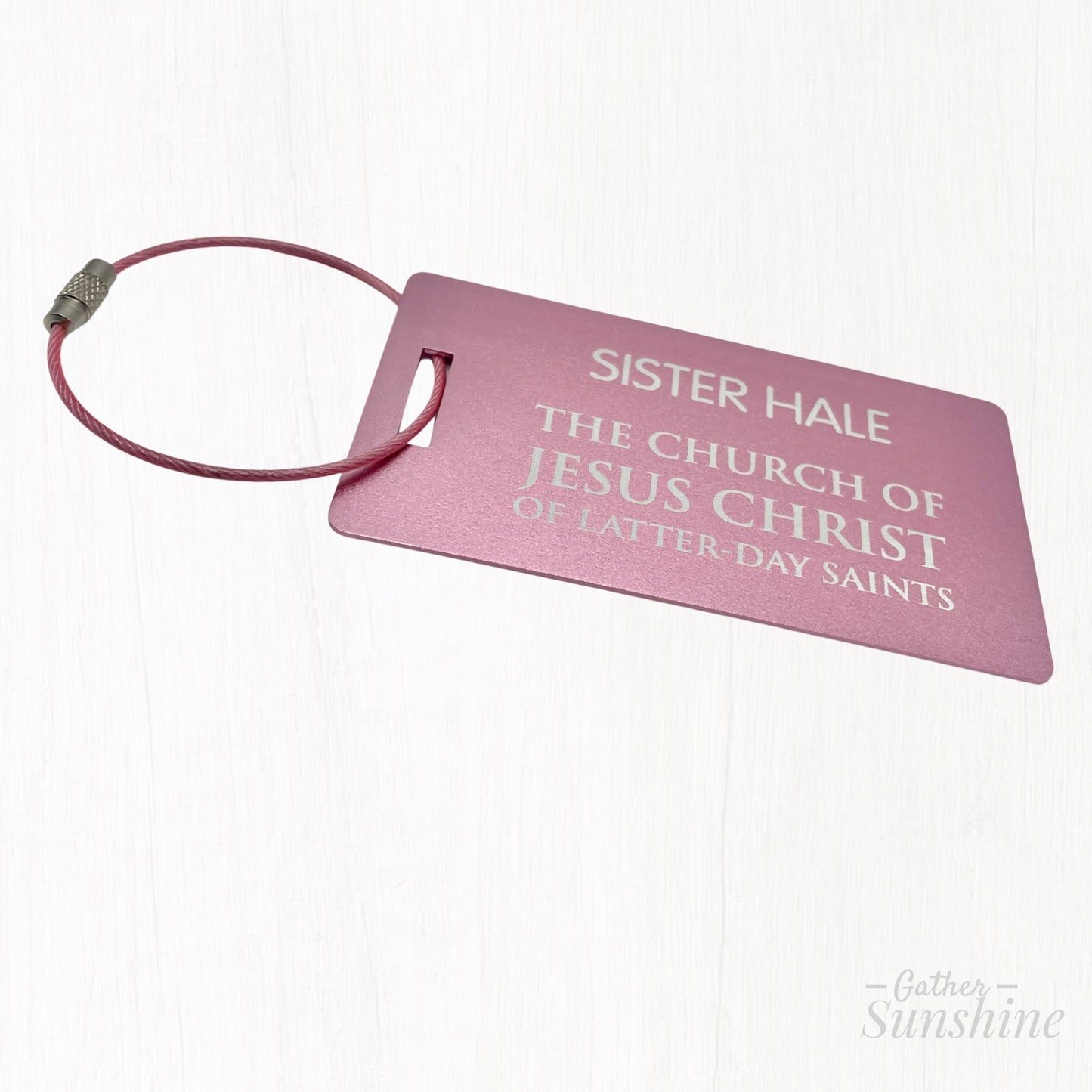 Pink LDS-style missionary luggage tag in English, shown at a different angle on white background. Size: 3.5x2 inch. A bold, colorful alternative by GatherSunshine.