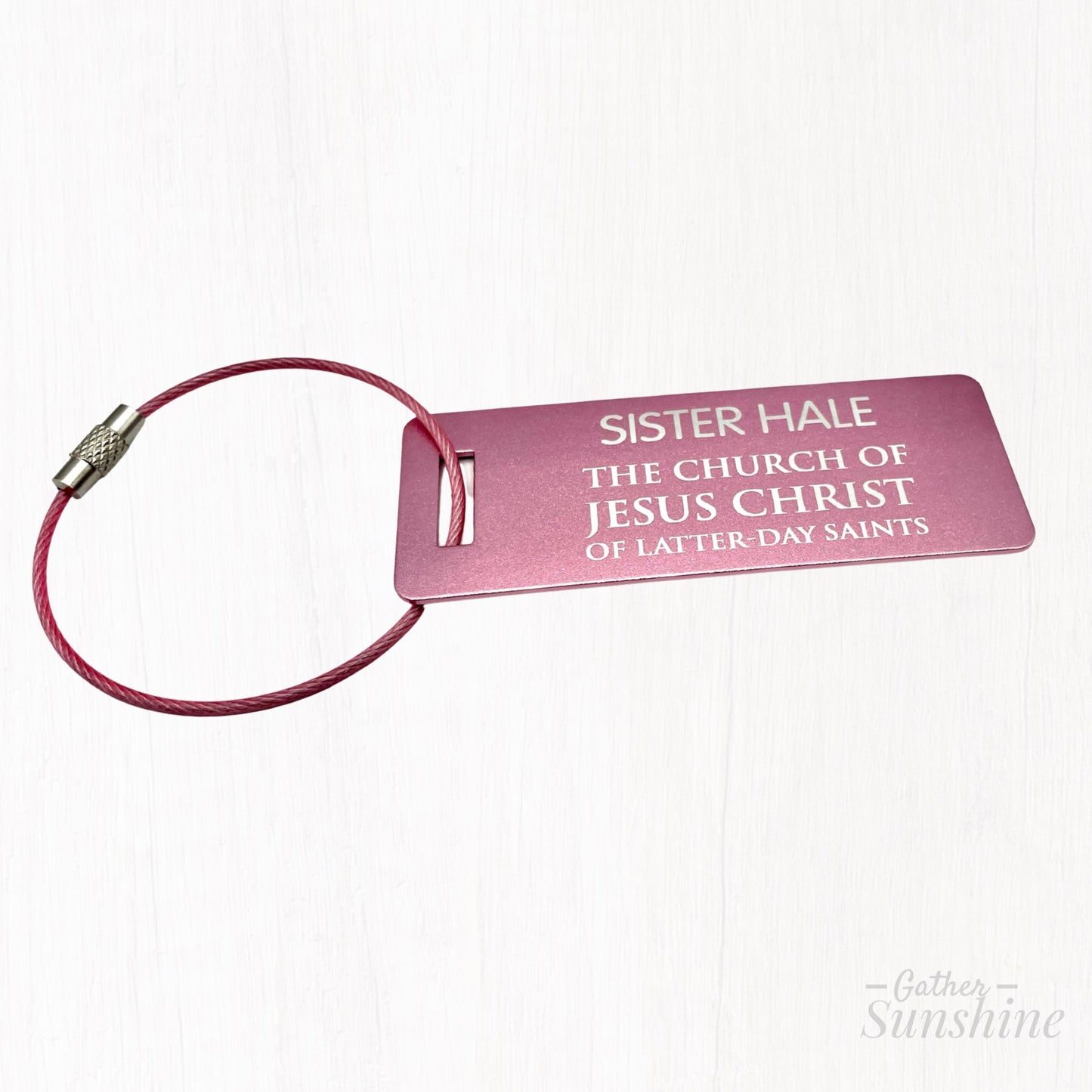 Pink LDS-style missionary small luggage tag in English, shown at a different angle on white background. Size: 3x1 inch. A bold, colorful alternative by GatherSunshine.