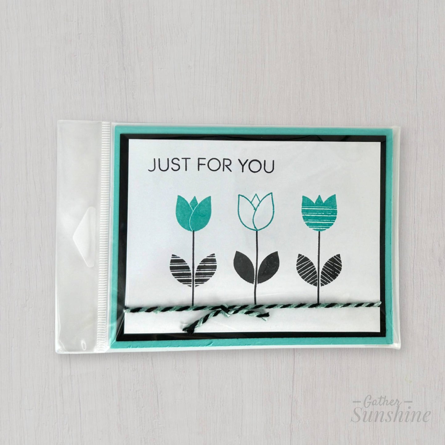 Hand-stamped aqua and black flower card in protective plastic sleeve with envelope, handmade by Gather Sunshine
