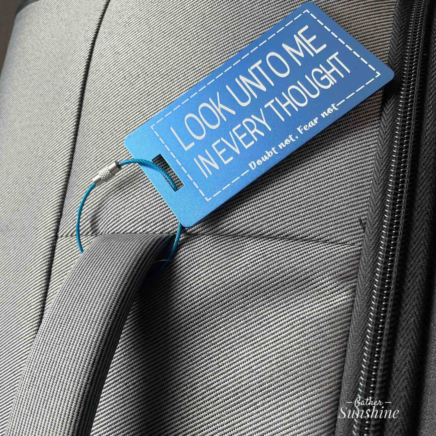 Large (3.5"x2") blue luggage tagswith motivational text "Look Unto Me In Every Thought, Doubt Not, Fear Not" on gray suitcase by Gather Sunshine.