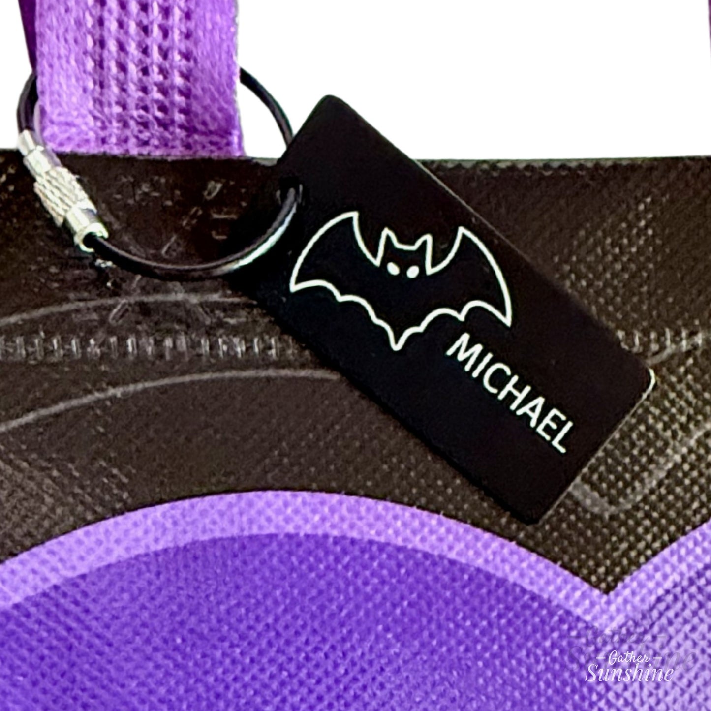 Halloween-themed purple bag with a closeup of tag with a bat with personalized name by Gather Sunshine.
