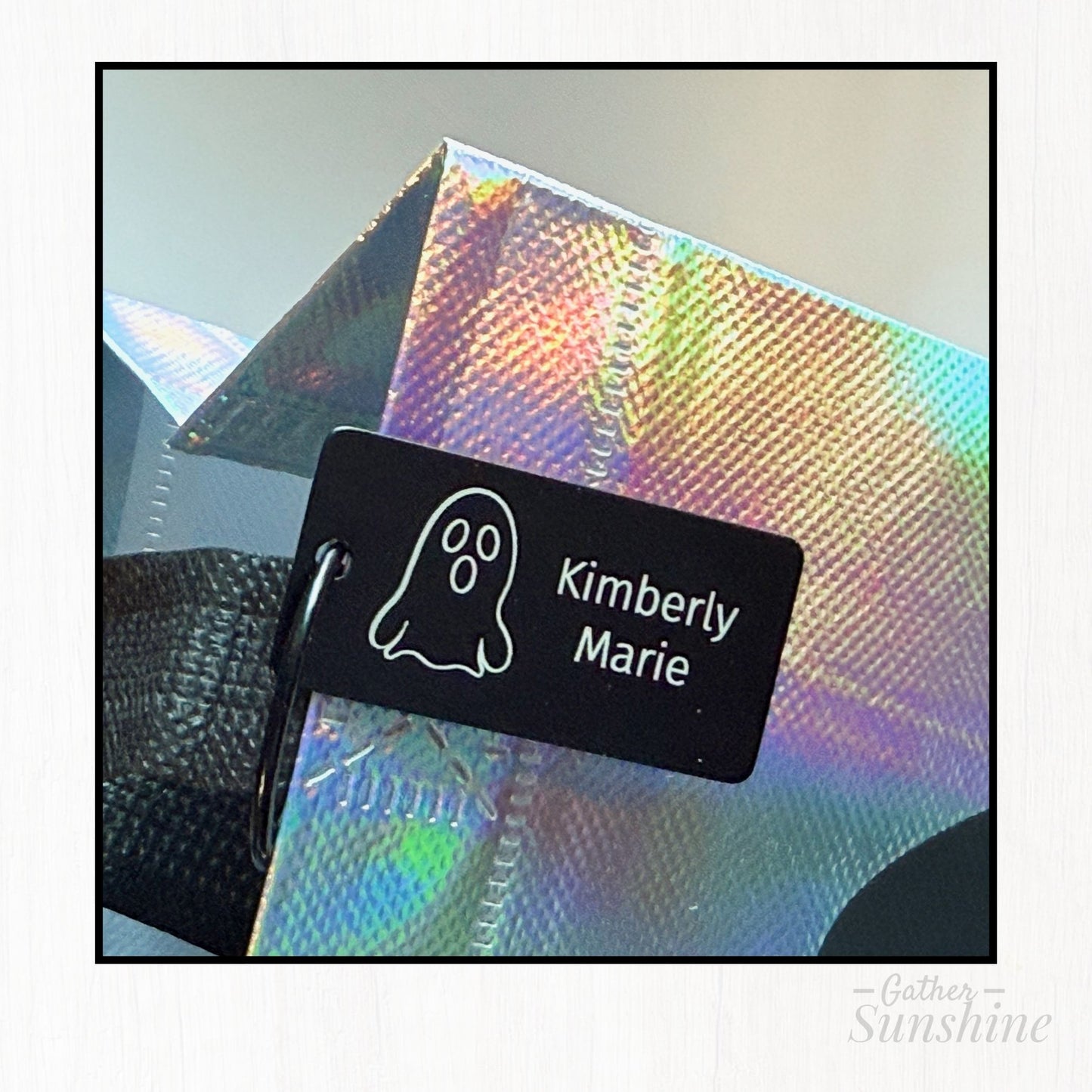 Close-up of engraved Halloween name tag attached to free iridescent ghost trick-or-treat bag from Gather Sunshine.