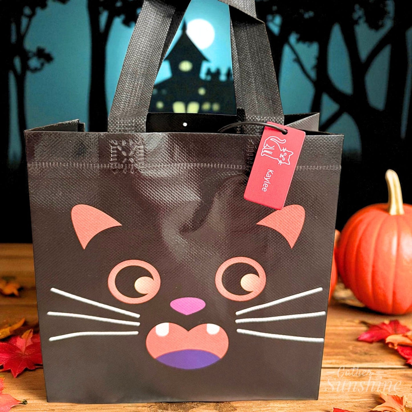 Cat Halloween tote bag with custom name tag in cozy fall setting by Gather Sunshine.