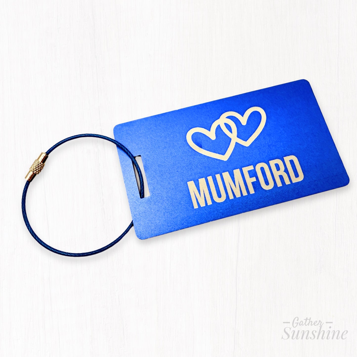 Large (3.5"x2") blue luggage tag customized with name of choice and two interlocking hearts. Personalized engraving by Gather Sunshine.