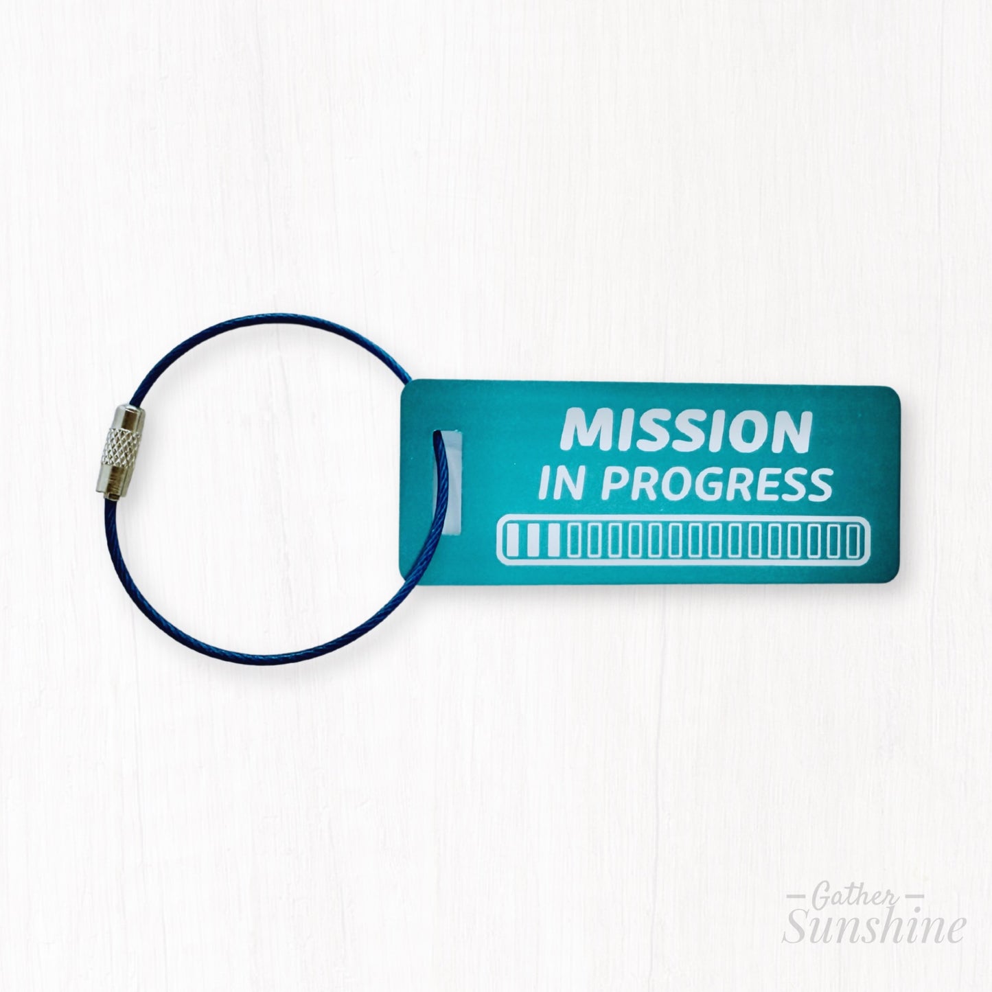 Small teal luggage tags engraved with “Mission in Progress” and 18 progress bars. LDS mission gift by GatherSunshine.