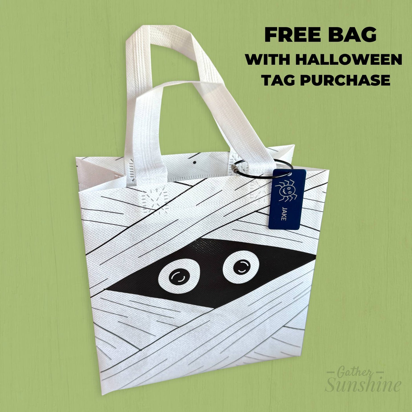 White mummy face trick-or-treat bag with engraved spider name tag personalized with child’s name, Gather Sunshine.