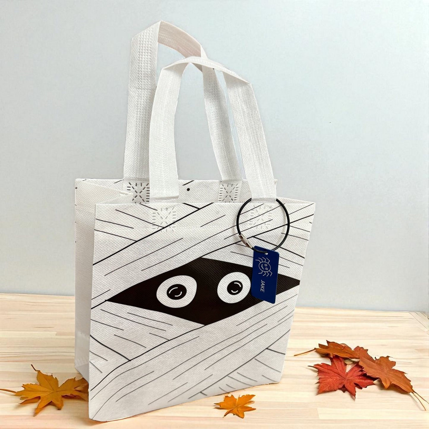 White mummy trick-or-treat bag with personalized engraved Halloween tag by Gather Sunshine.