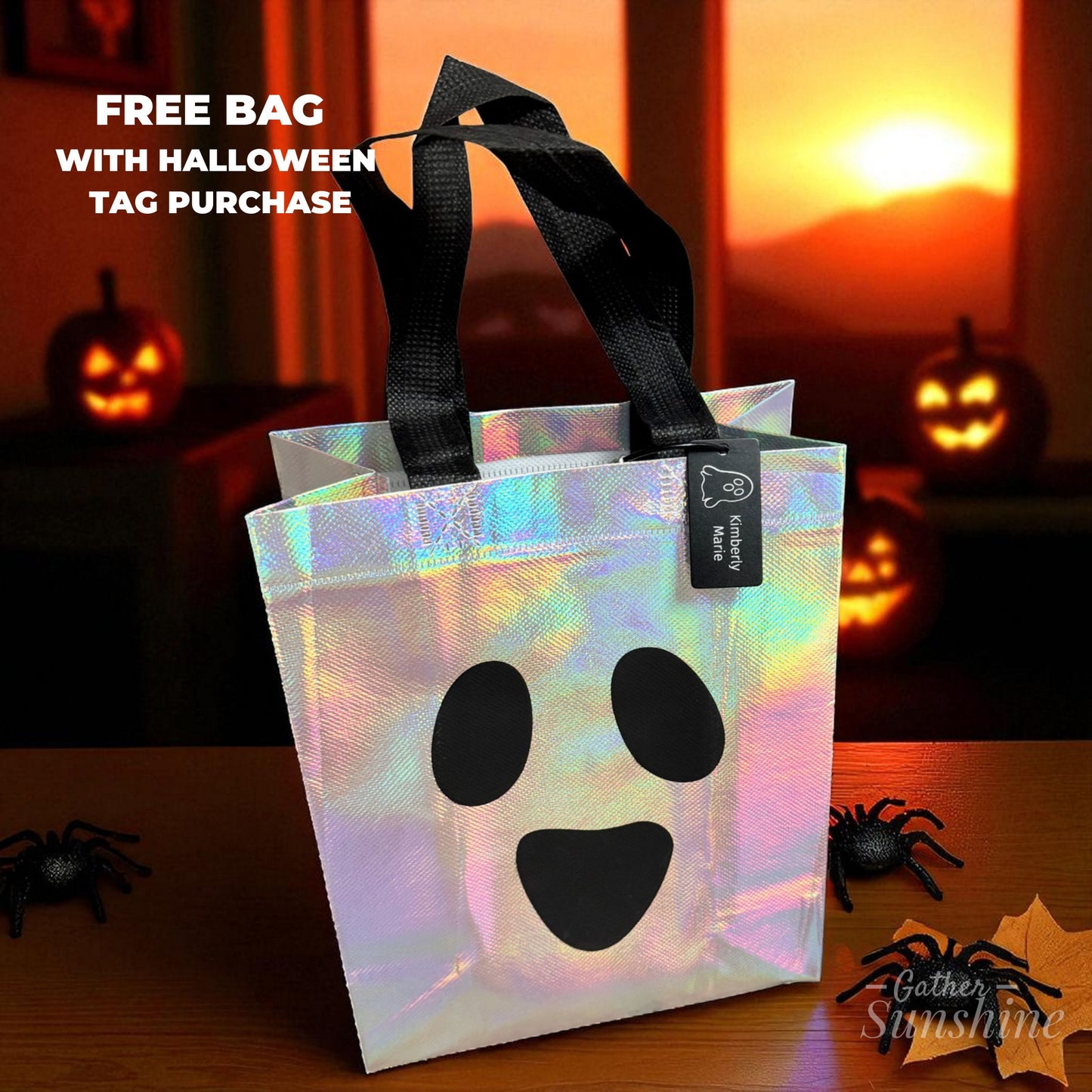 Holographic ghost-shaped Halloween bag with black handles on a table with personalized Halloween tag with engraved ghost design on black metal tag by Gather Sunshine