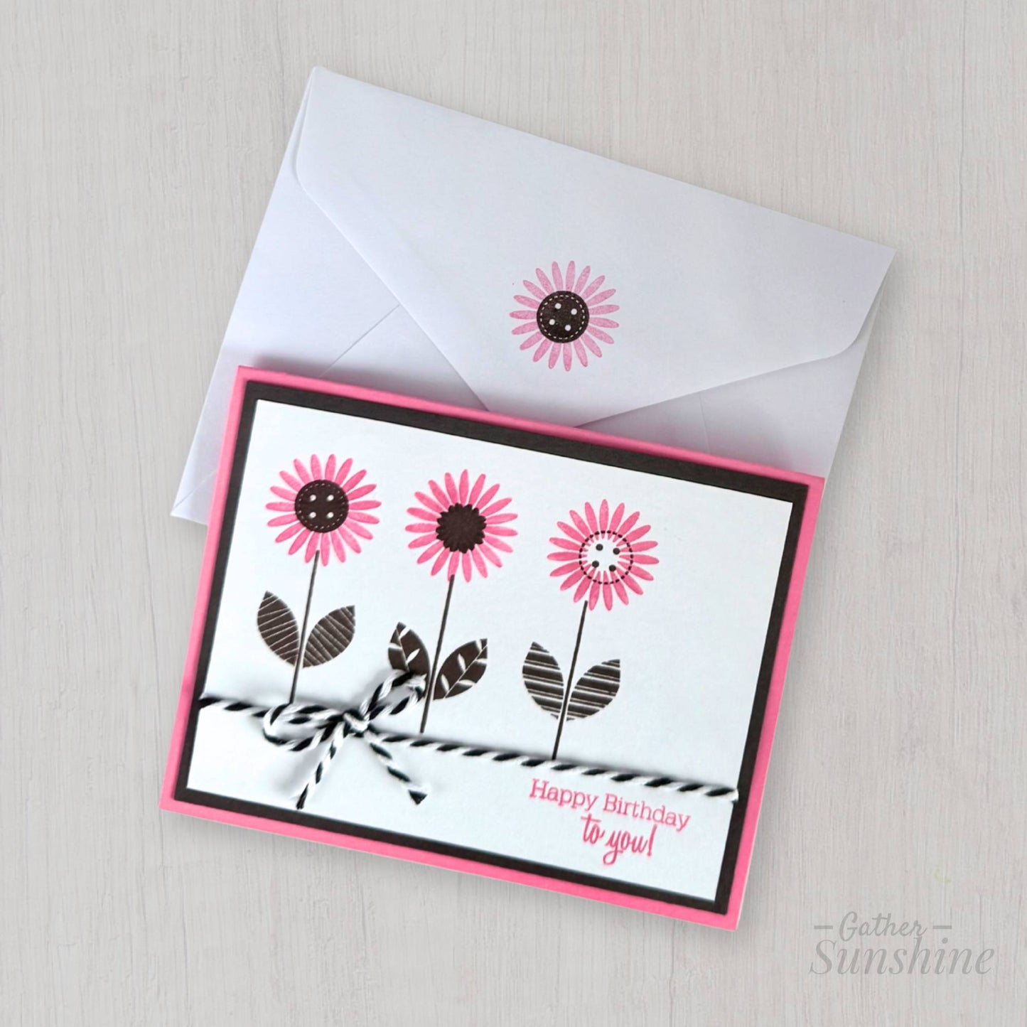 Handmade pink flower birthday card with “Happy birthday to you” phrase, layered cardstock, resting on envelope by Gather Sunshine