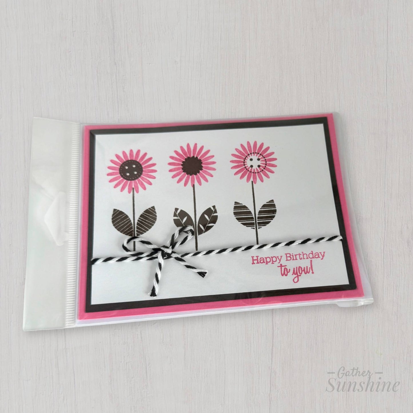 Handmade pink flower birthday card with smokey black accents in protective plastic sleeve, created by Gather Sunshine