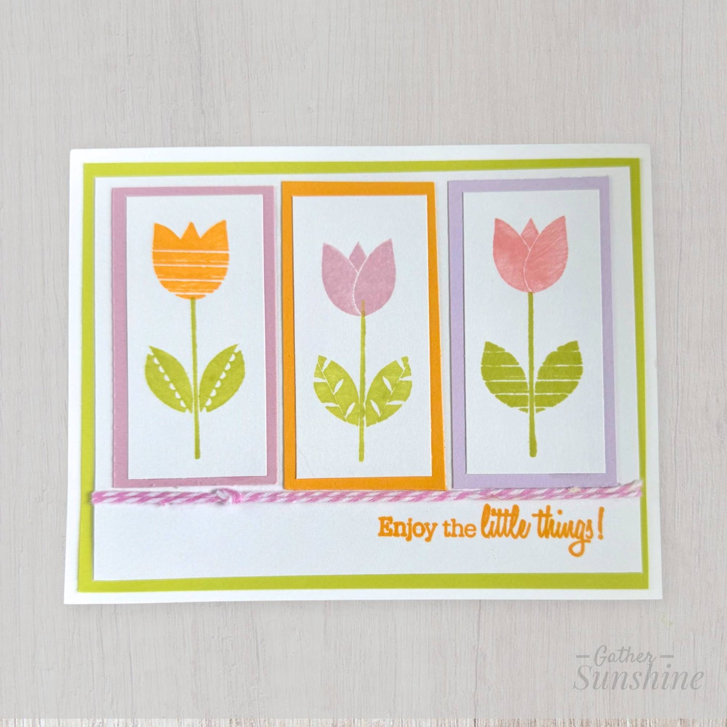 Hand-stamped tulip floral card with layered spring colors, bow, and “Enjoy the little things” phrase, designed by Gather Sunshine