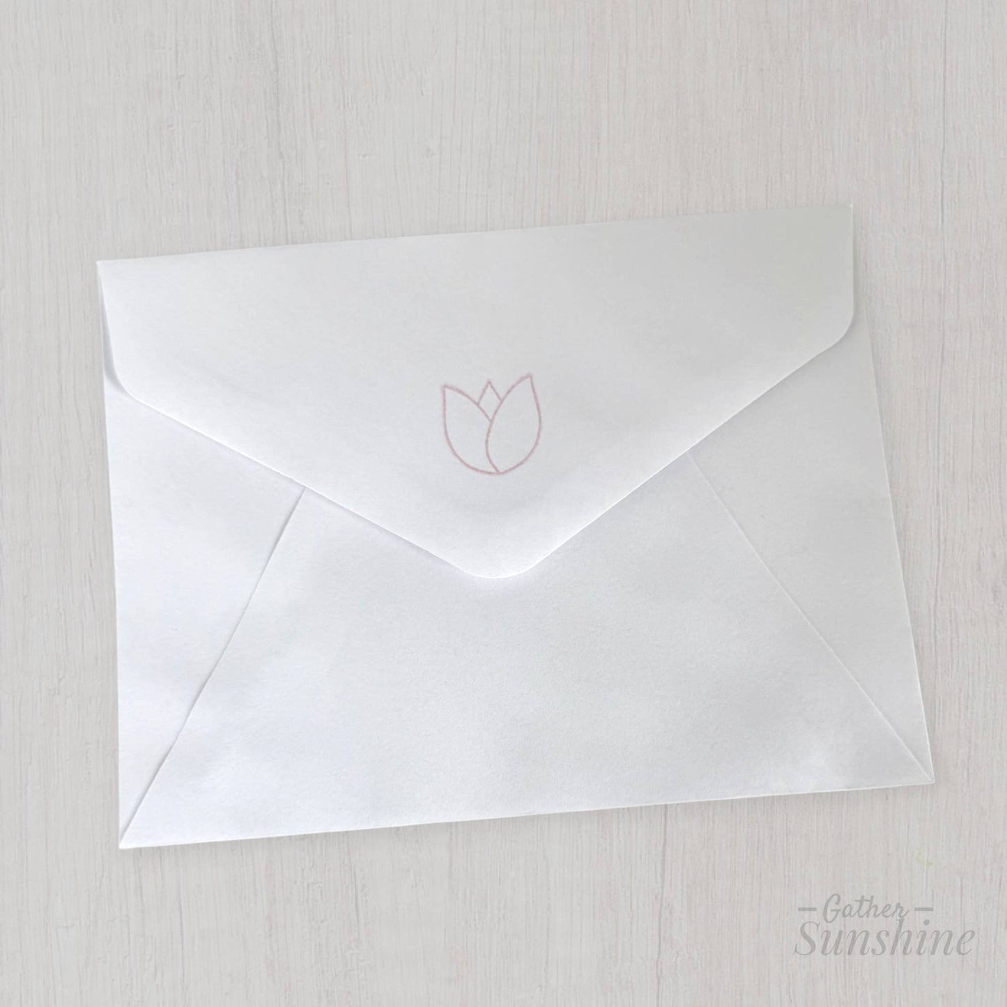 White envelope stamped with tulip design on flap, matching handmade “Enjoy the little things” card by Gather Sunshine