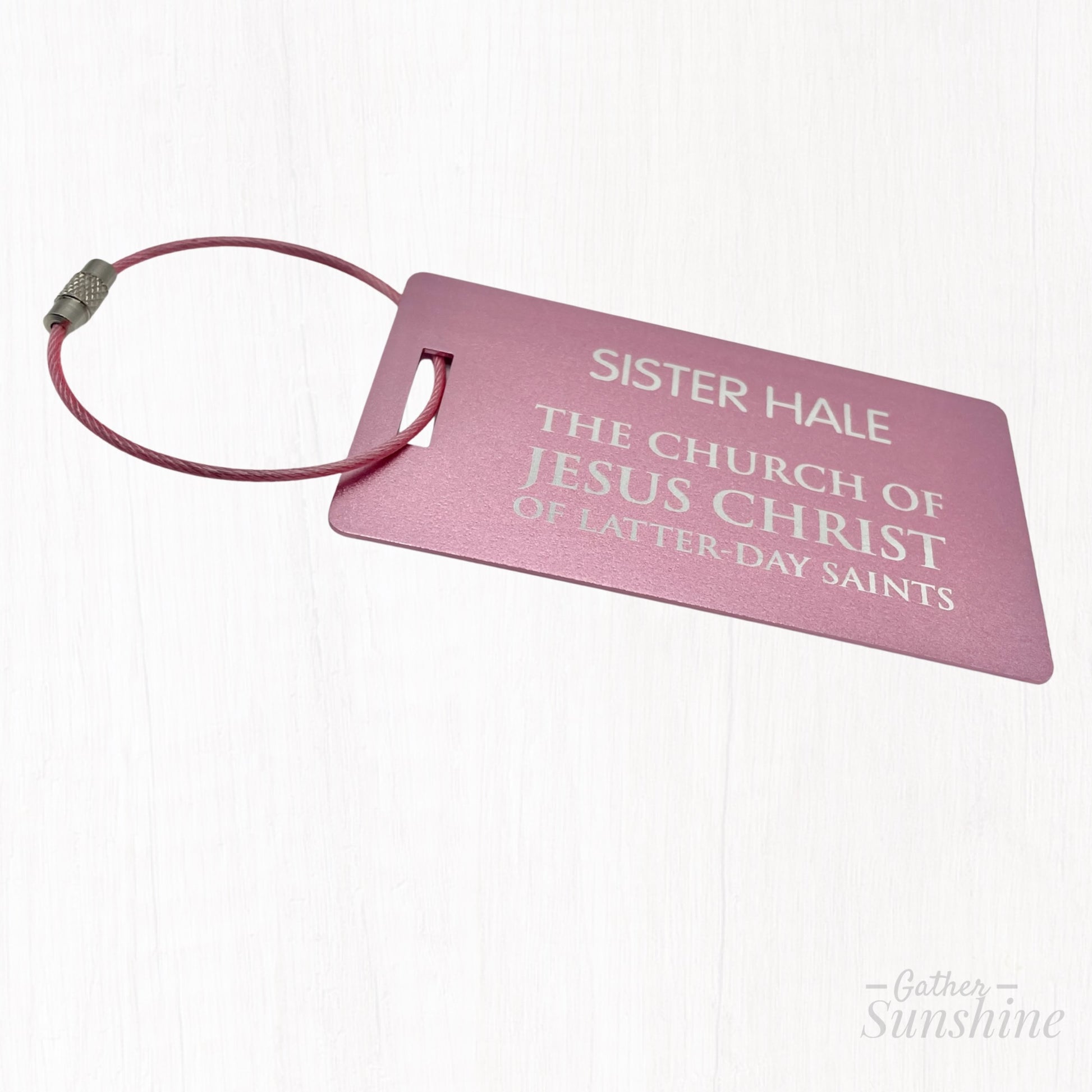Pink LDS-style missionary luggage tag in English, shown at a different angle on white background. Size: 3.5x2 inch. A bold, colorful alternative by GatherSunshine.