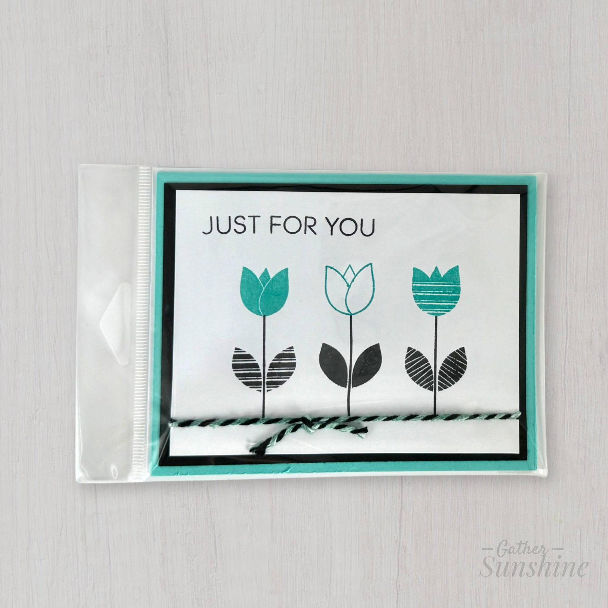 Hand-stamped aqua and black flower card in protective plastic sleeve with envelope, handmade by Gather Sunshine