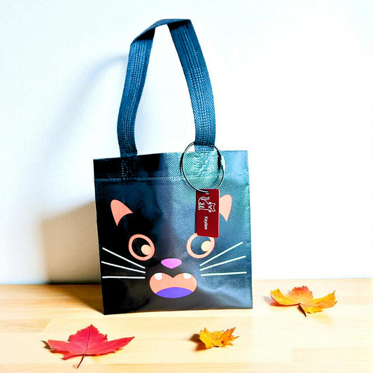 Black cat Halloween trick-or-treat bag with personalized engraved Halloween tag by Gather Sunshine.