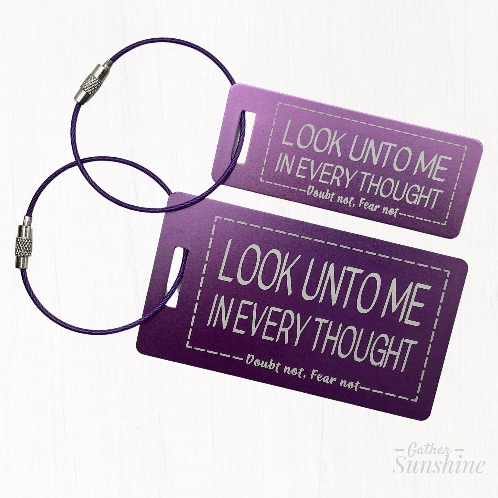 Small (3"x1") and large (3.5"x2") purple luggage tags with motivational text "Look Unto Me In Every Thought, Doubt Not, Fear Not" by Gather Sunshine.