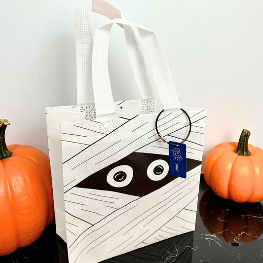 White mummy trick-or-treat bag with personalized engraved Halloween tag by Gather Sunshine.