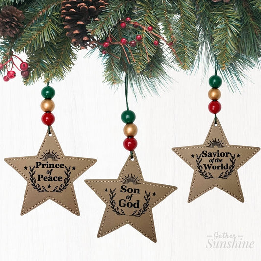 Star-shaped Christmas ornaments with Names of Christ text hanging from a decorated tree by Gather Sunshine.