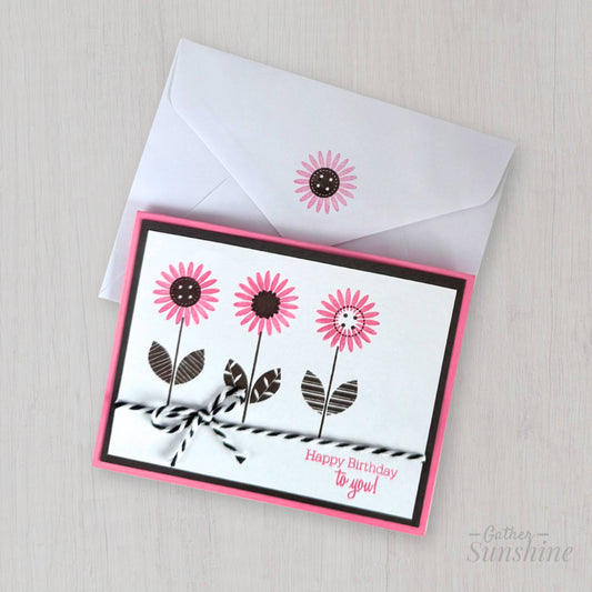 Handmade pink flower birthday card with “Happy birthday to you” phrase, layered cardstock, resting on envelope by Gather Sunshine