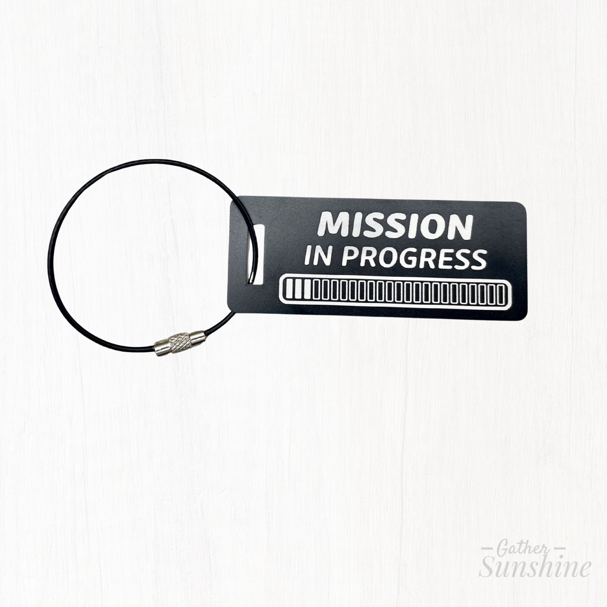 Small black 3x1 inch “Mission in Progress” tag featuring an engraved 24 progress bars design. Personalized LDS missionary gift by GatherSunshine.