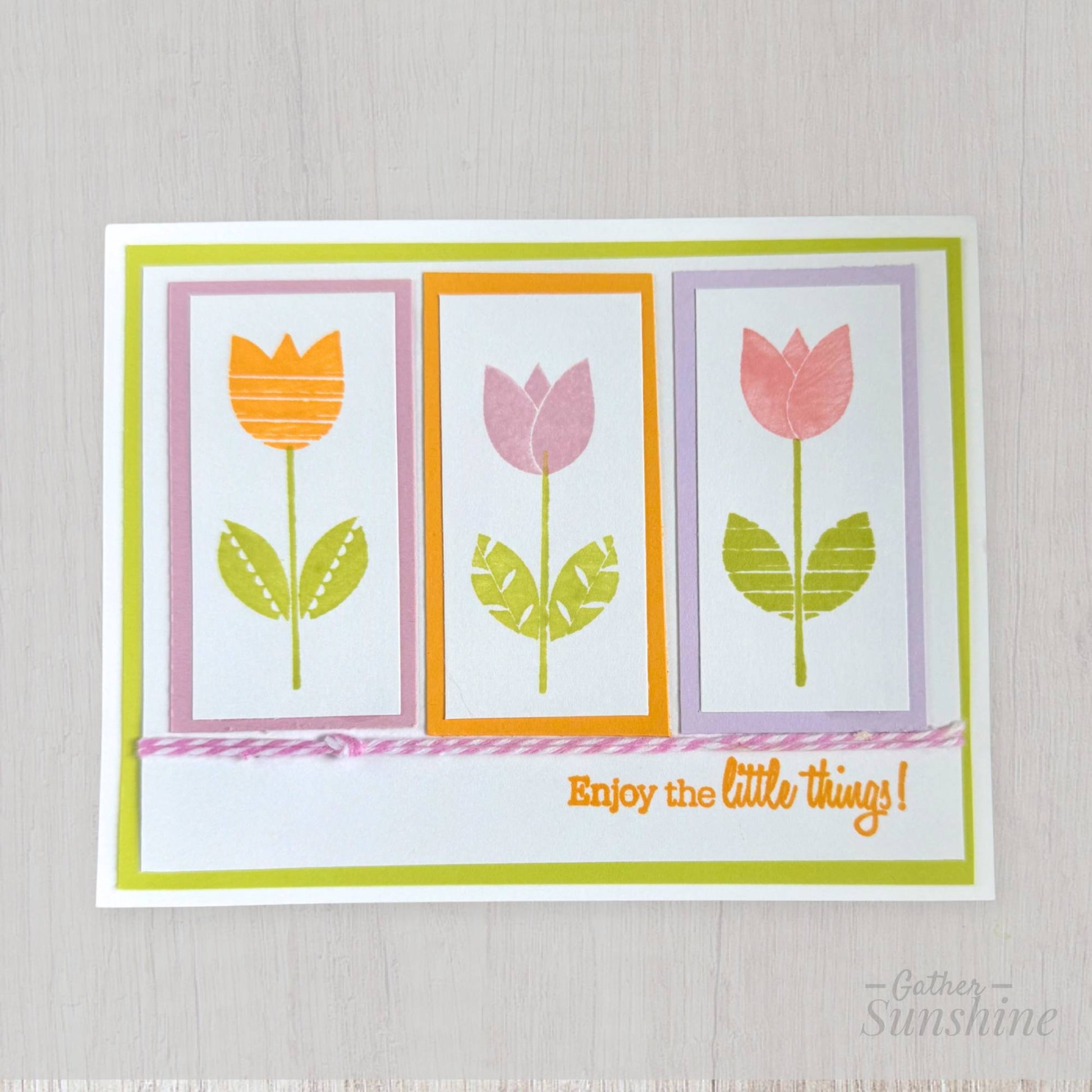 Hand-stamped tulip floral card with layered spring colors, bow, and “Enjoy the little things” phrase, designed by Gather Sunshine