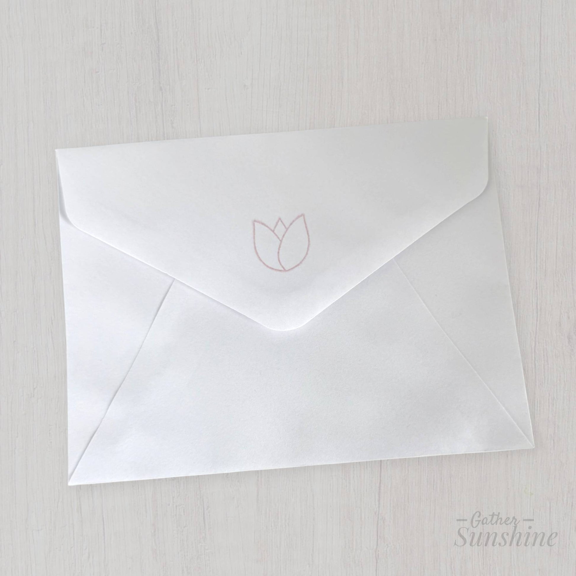 White envelope stamped with tulip design on flap, matching handmade “Enjoy the little things” card by Gather Sunshine